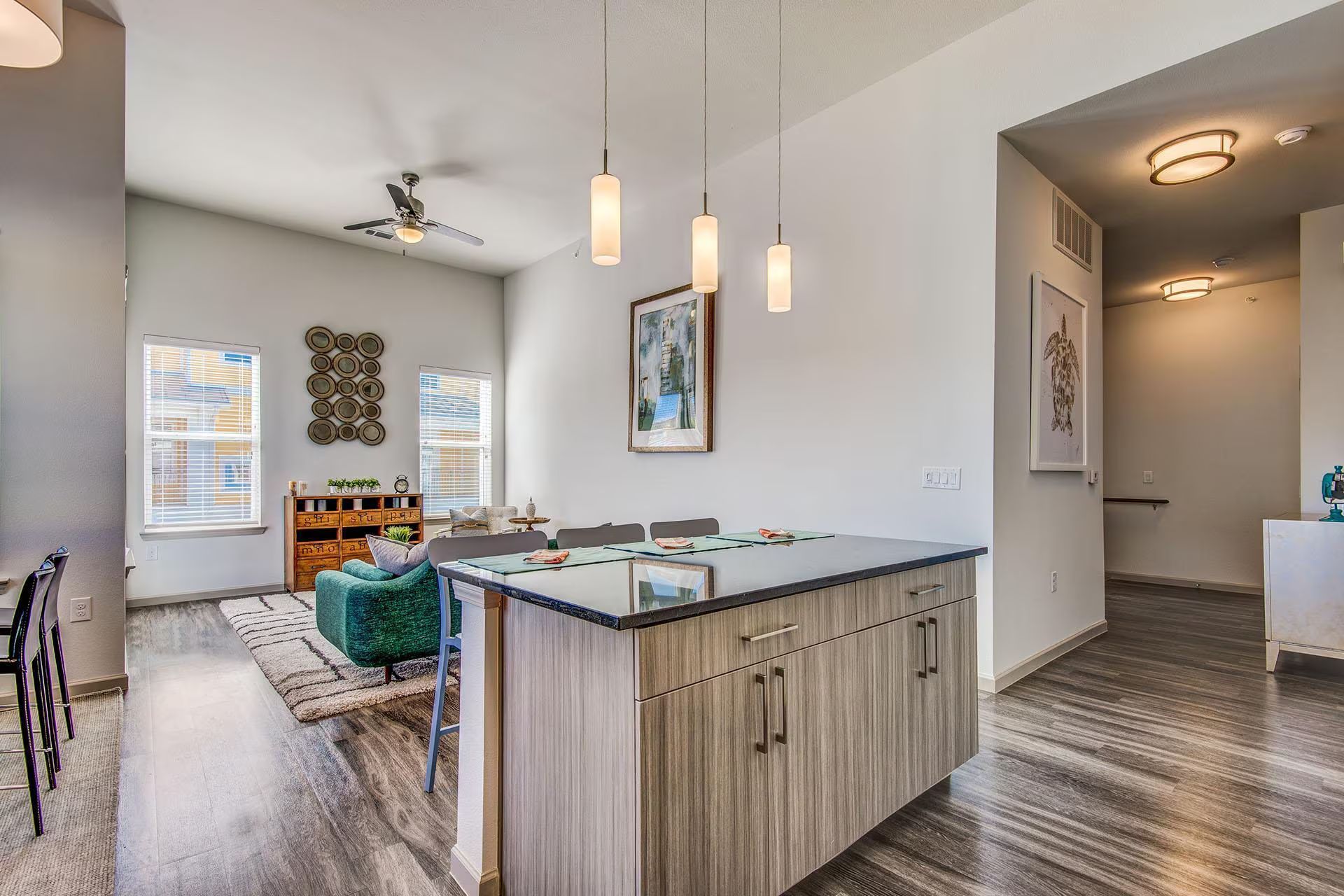 Modern apartment interior with kitchen island, living area, and entryway.