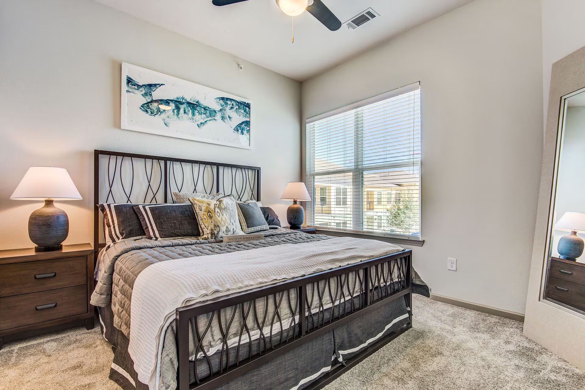 Bedroom with a bed, two nightstands, a window, and artwork on the wall.