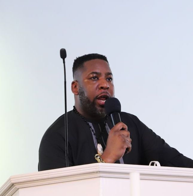 A man speaking into a microphone at a podium