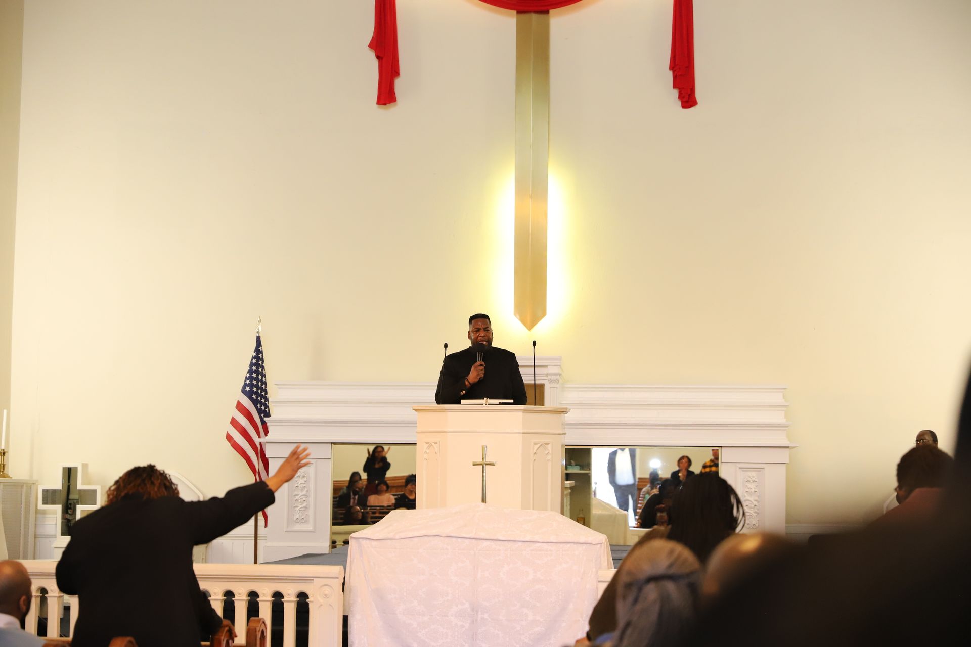 A man is giving a speech in front of a crowd in a church