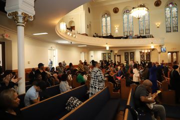 A large group of people are sitting in a church.