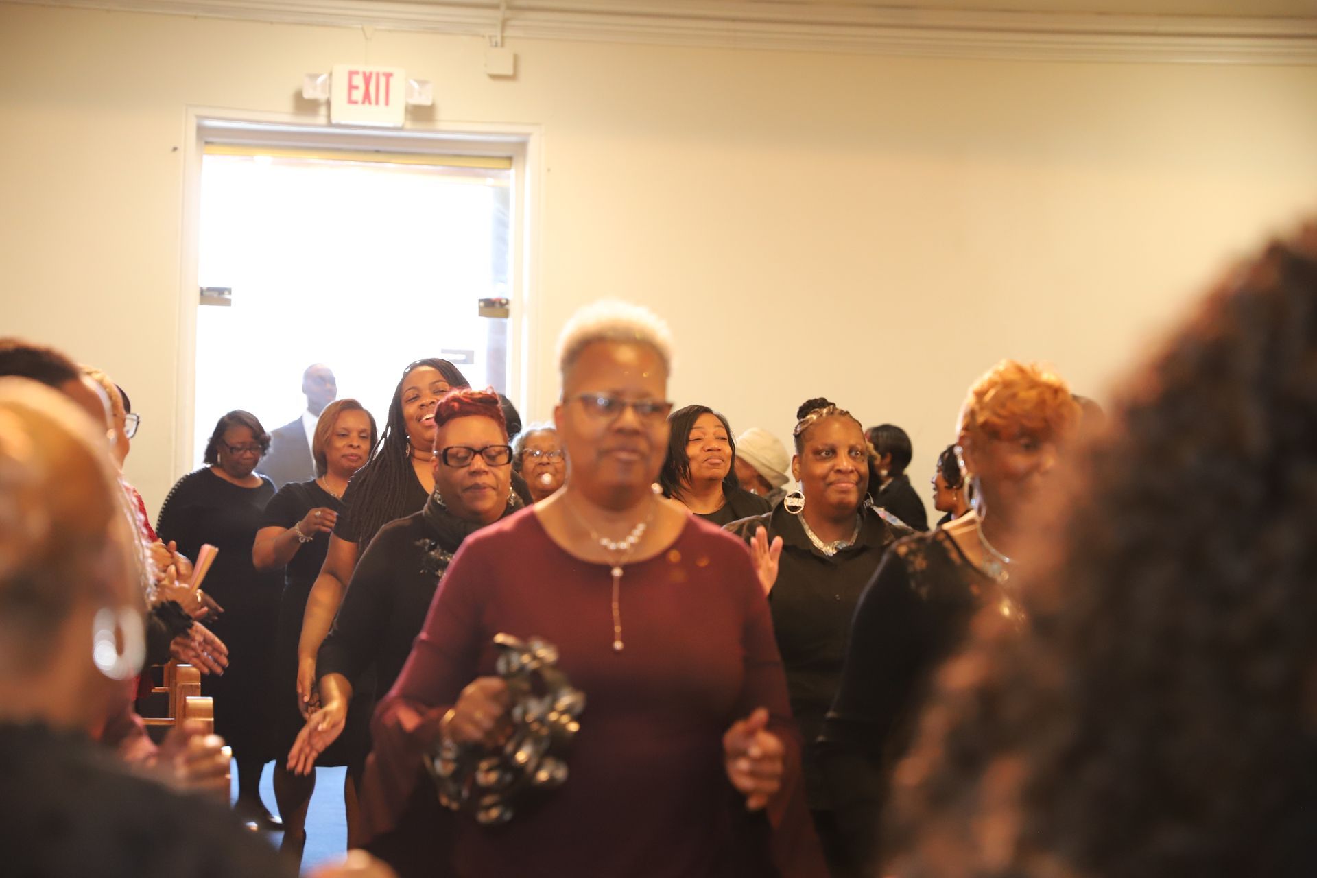 A group of women are dancing in a room while holding tambourine.