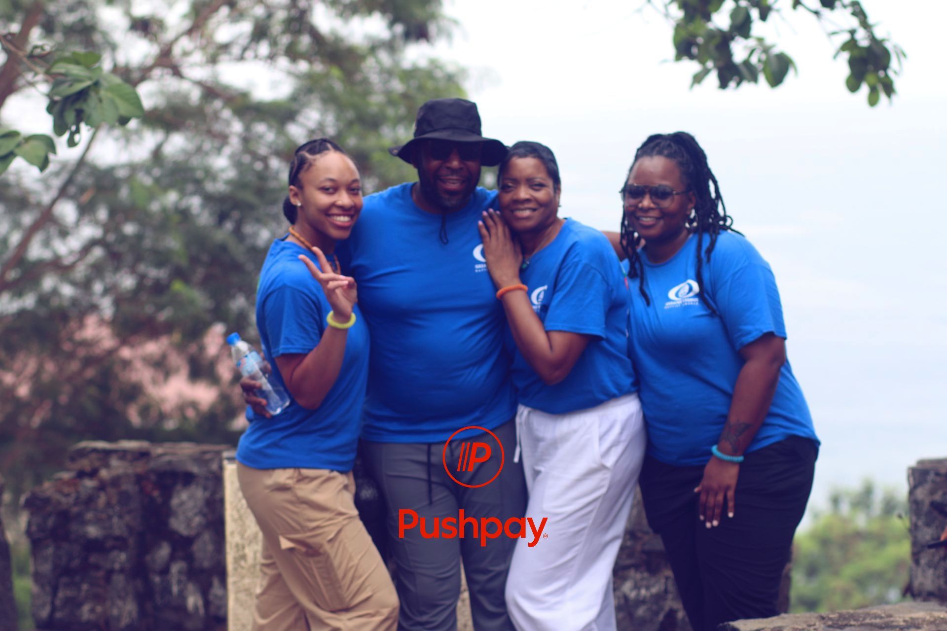 A group of people posing for a picture with the word pushpay in the corner