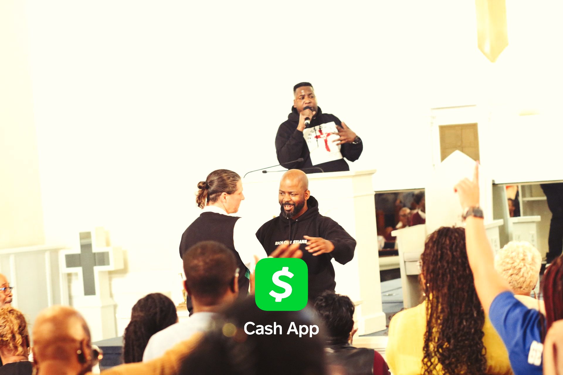 A man is giving a speech in front of a crowd of people in a church.