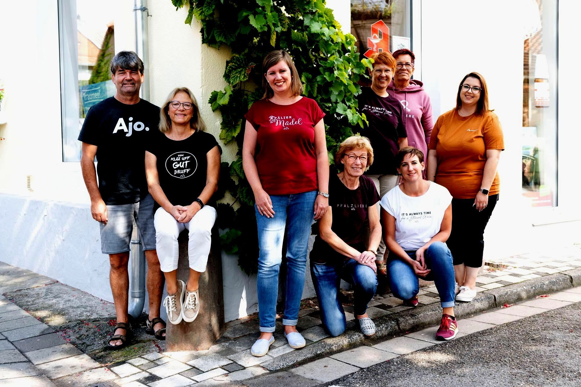 Eine Gruppe von Menschen posiert vor einem Gebäude für ein Foto.