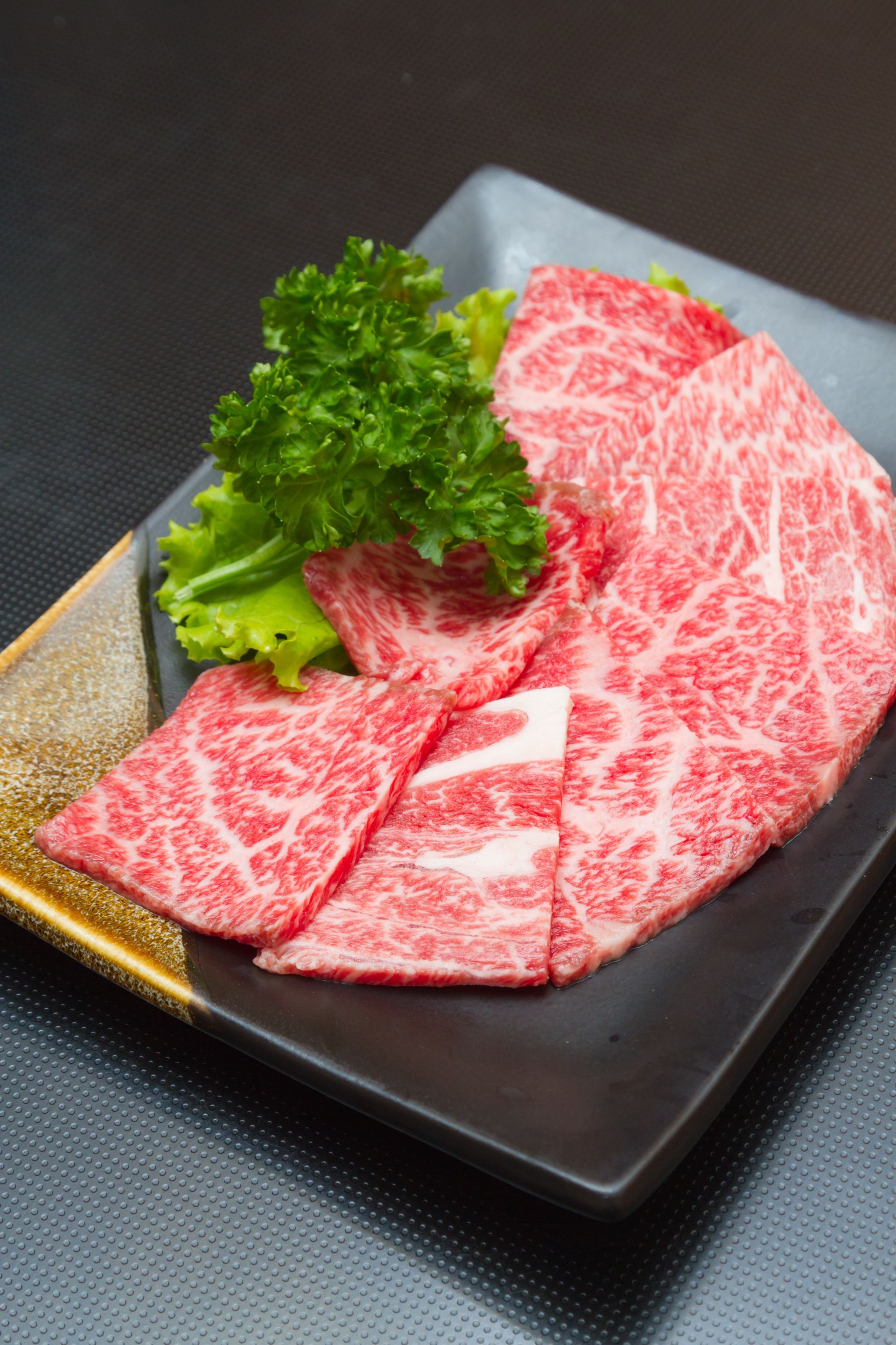 JPOT Japanese hot pot and BBQ thinly sliced marbled beef on a gold and black rectangular plate 