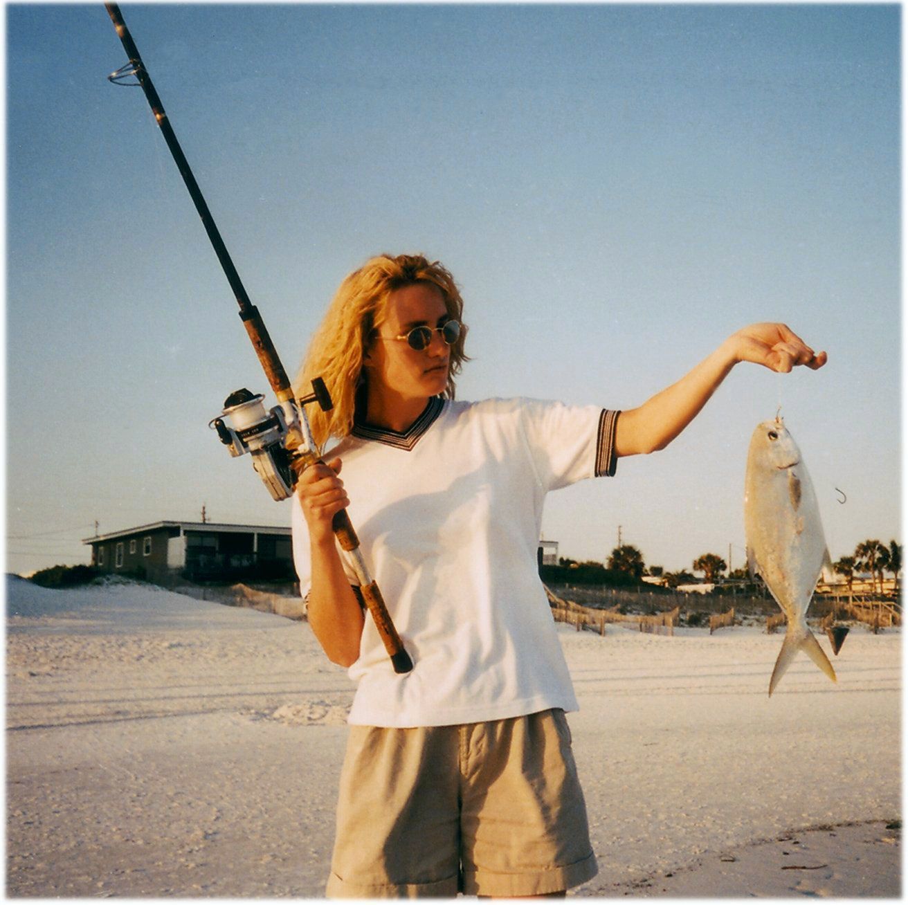 A woman holding a fishing rod and a fish