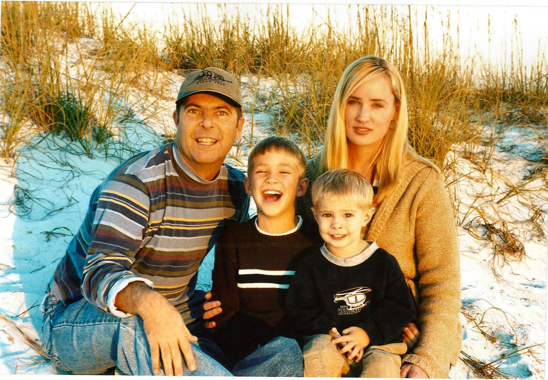 A family posing for a picture on a sandy beach