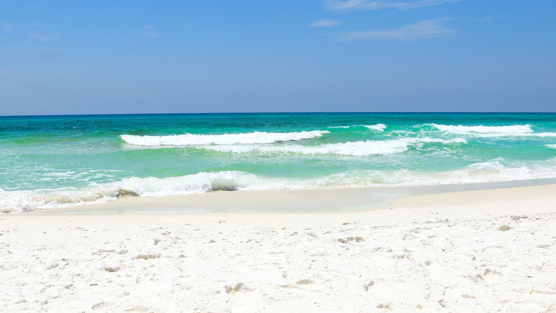 A white sandy beach with a blue ocean in the background.