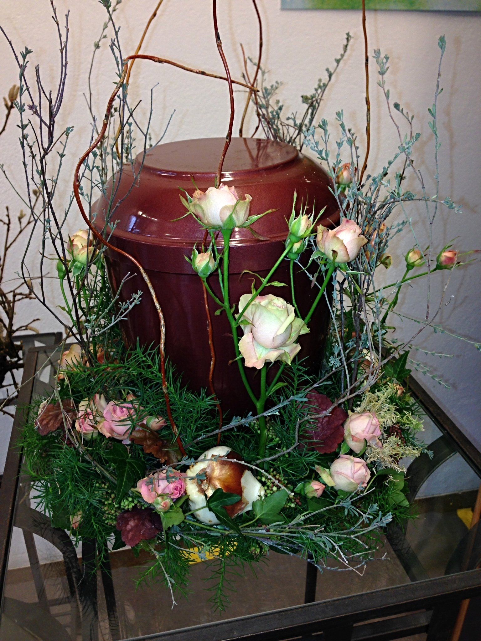 Eine Urne ist von Blumen umgeben auf einem Tisch