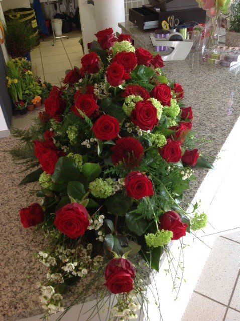 Ein Strauß roter Rosen liegt auf einer Theke