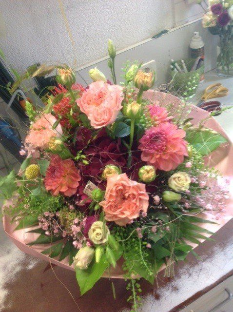 Auf einem Tisch vor einem Spiegel steht ein Blumenstrauß.