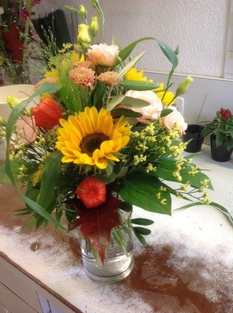 Eine Vase gefüllt mit Sonnenblumen und anderen Blumen