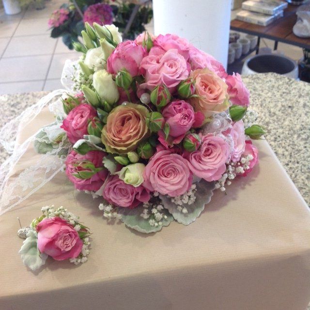 Auf einem Tisch steht ein Strauß rosa und weißer Blumen.