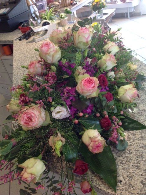 Auf einem Tisch steht ein Strauß rosa und violetter Blumen.