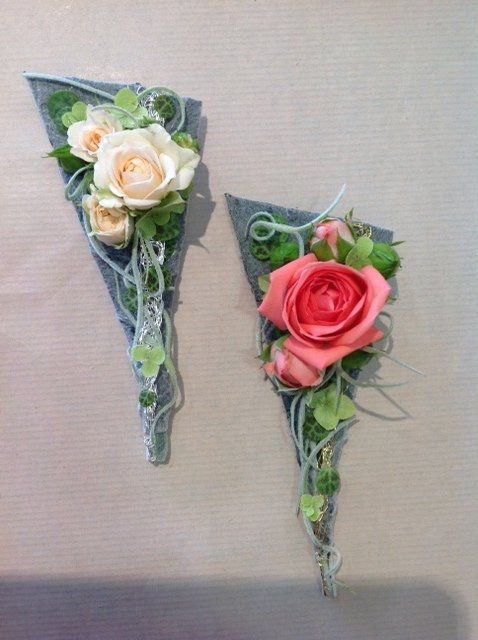 Auf einem Tisch liegen zwei Dreiecke mit Blumen darauf.