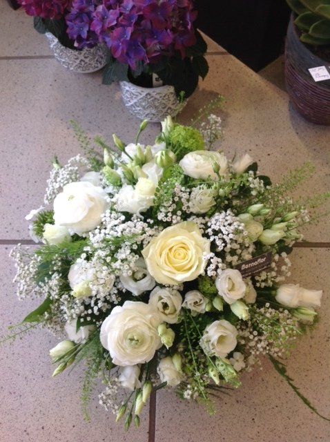 Auf einem gefliesten Boden steht ein Strauß weißer Blumen.