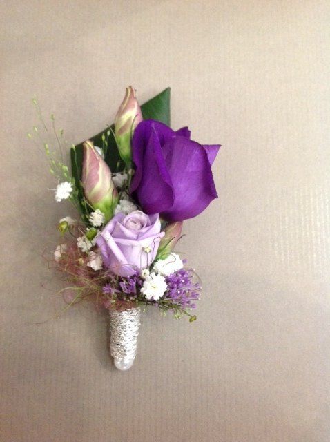 Auf einem Tisch steht ein kleiner Strauß lila Blumen.