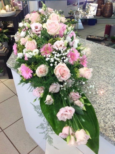 Ein Strauß rosa und weißer Blumen auf einer Theke