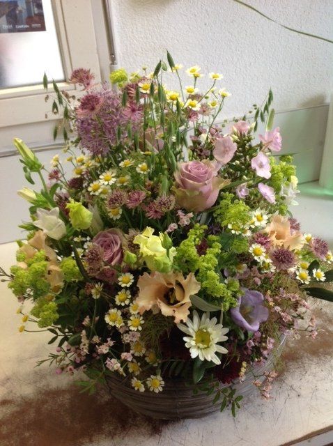 Ein mit Blumen gefüllter Korb steht auf einem Tisch