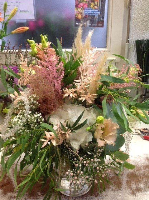 Auf einem Tisch steht eine mit Blumen gefüllte Vase.