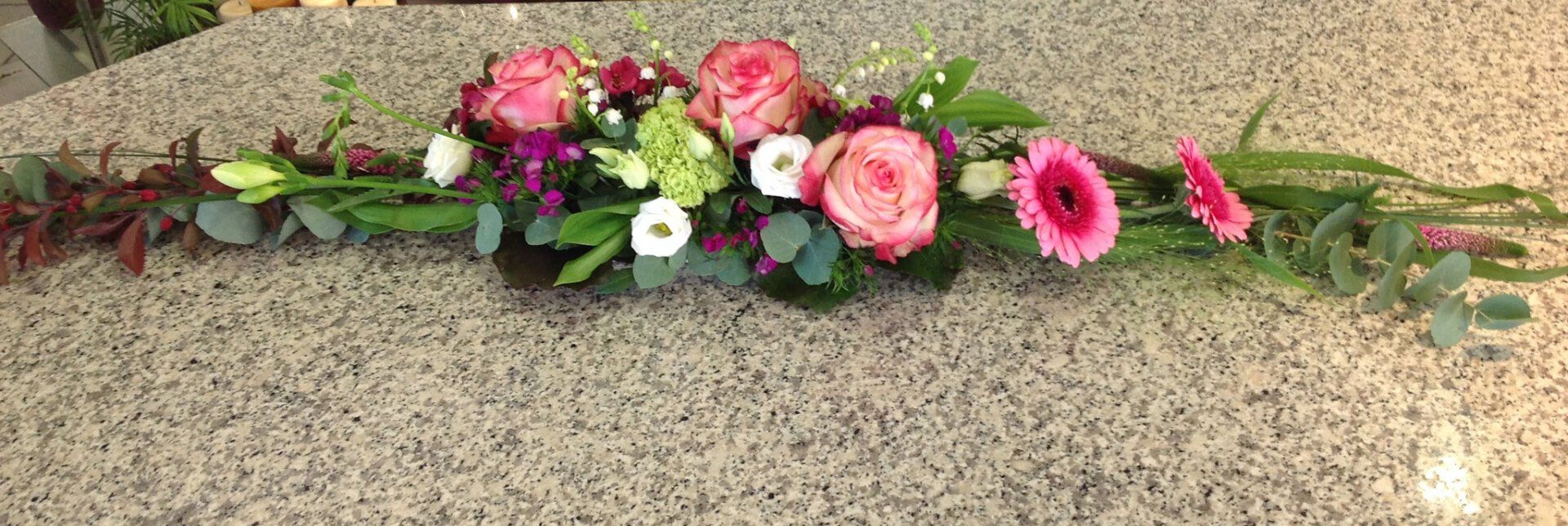 Auf einer Theke steht ein Blumenstrauß.