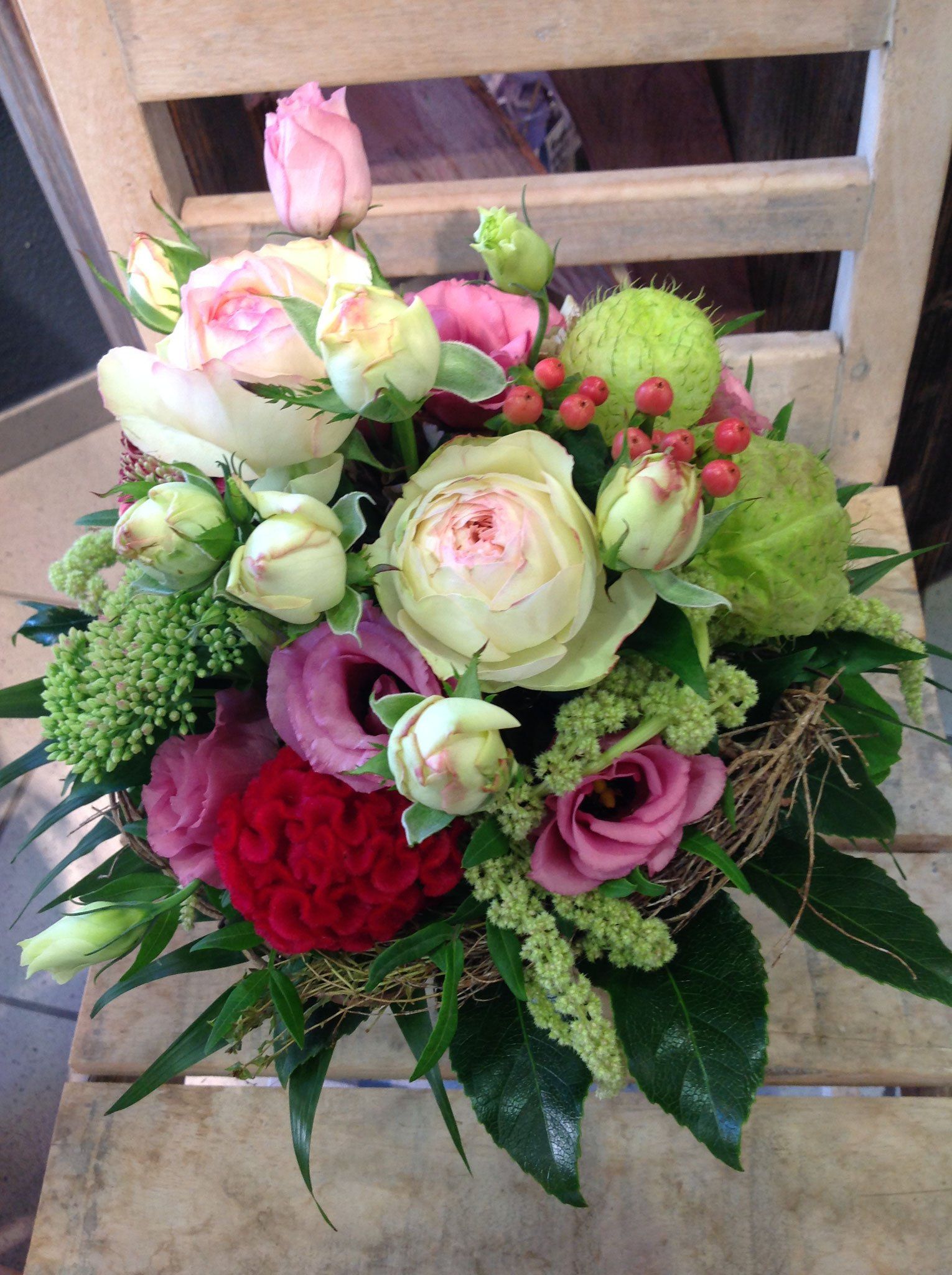 Auf einem Holzstuhl steht ein Blumenstrauß.