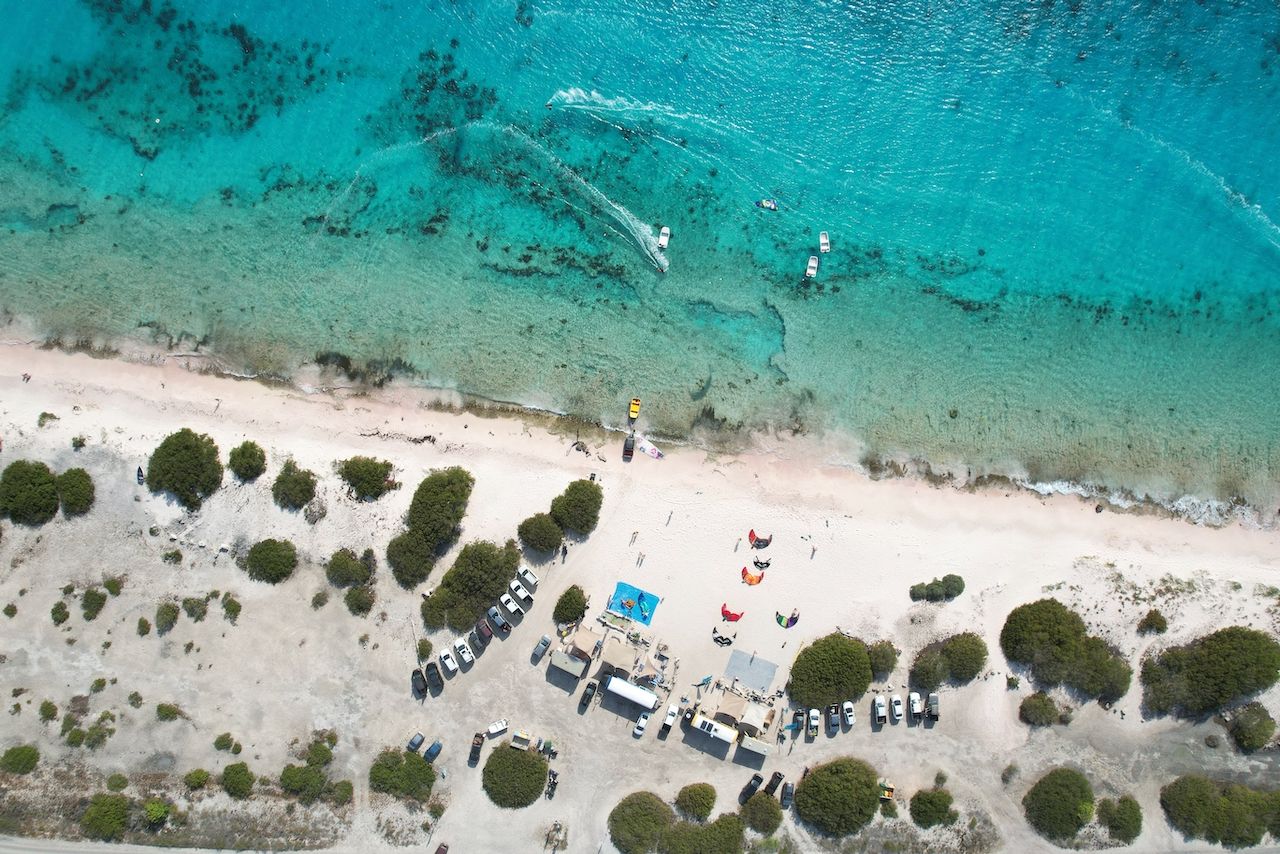 An aerial view of a beach with boats in the water.