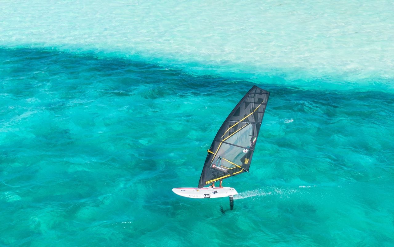 An aerial view of a person windsurfing in the ocean.