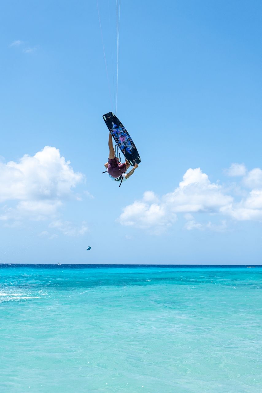 A beach with waves crashing against the rocks on a sunny day