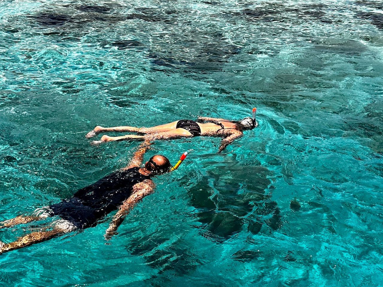 A man and a woman are swimming in the ocean.