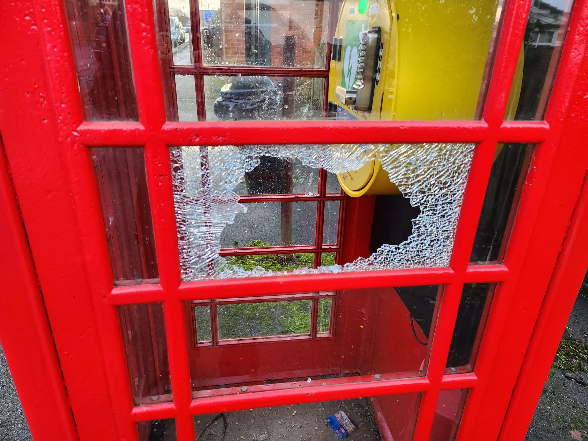 Broken window at the phone box in Newton