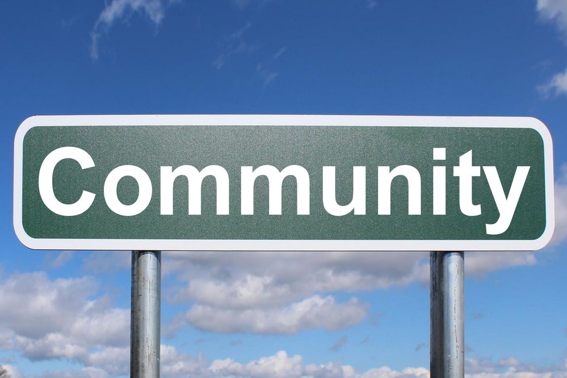 A photo showing a Community sign against blue sky.