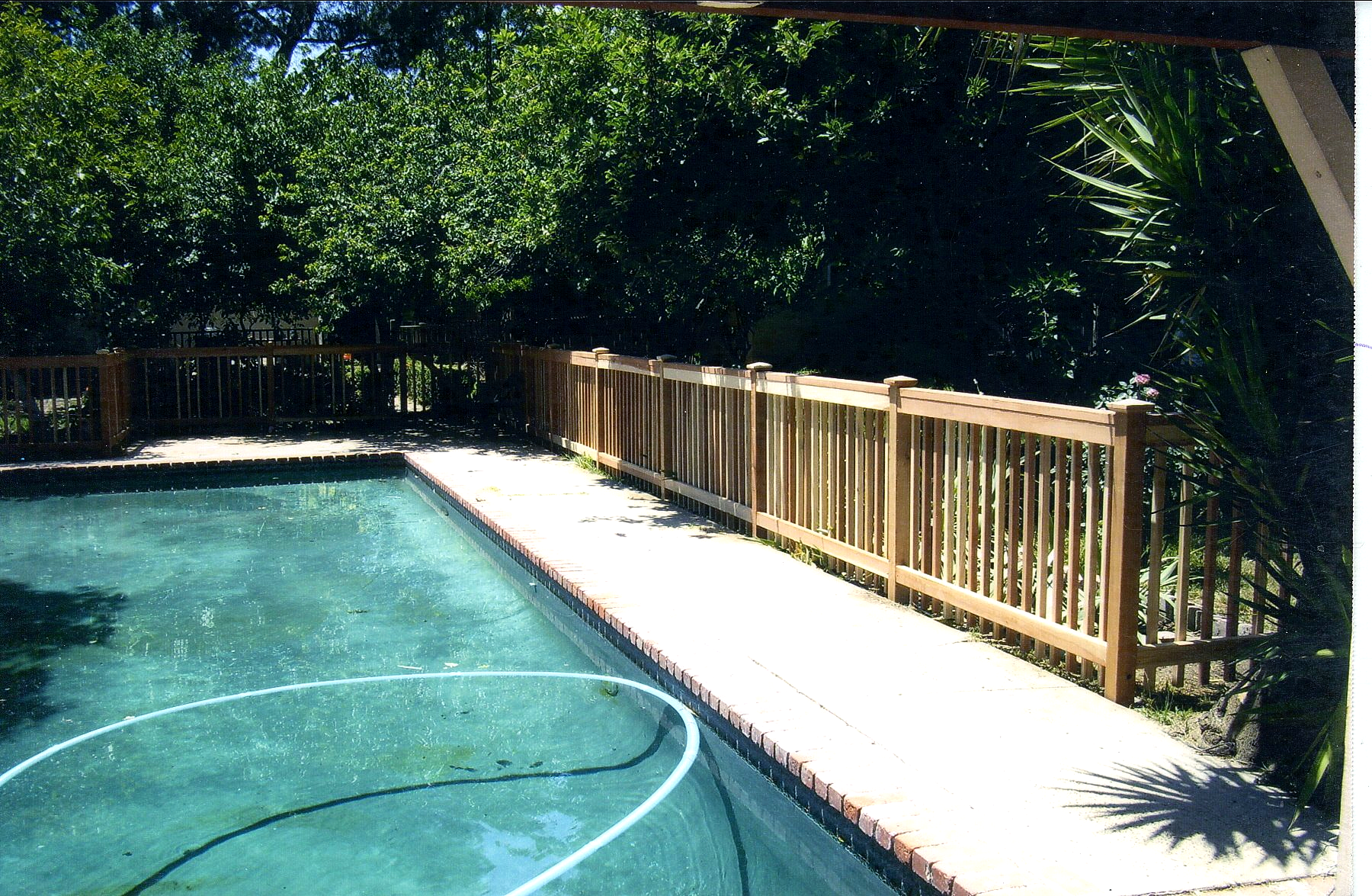 A swimming pool with a wooden fence around it