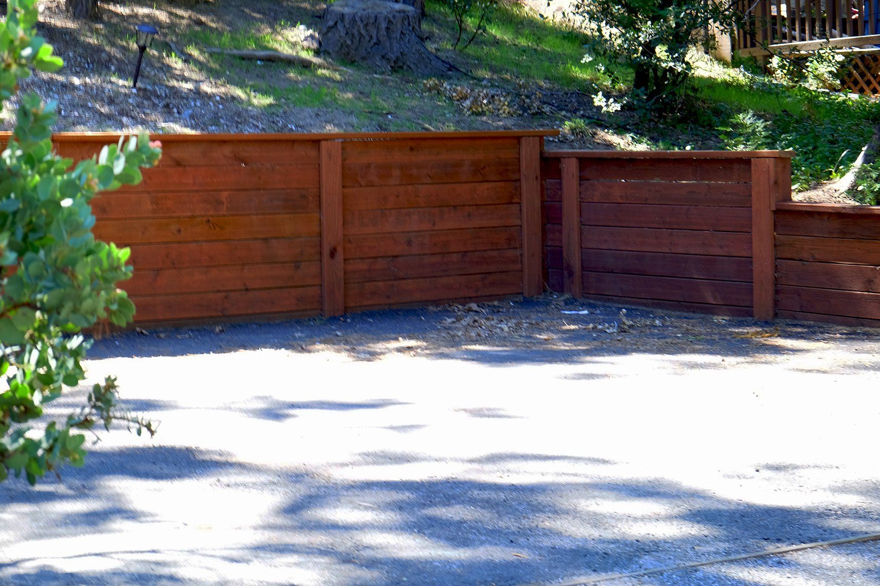 A wooden fence is sitting on the side of a road.