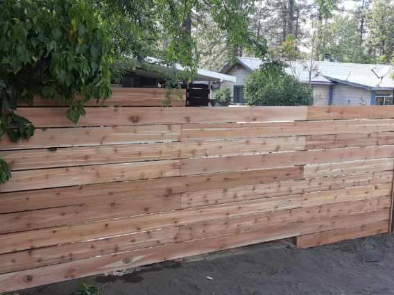 A wooden fence is being built in front of a house.