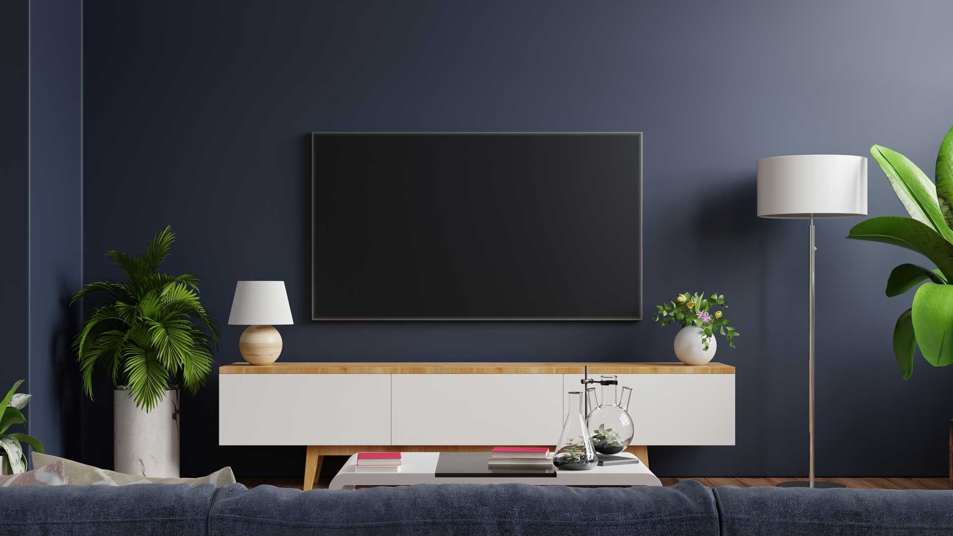 Wooden deck with chairs and table overlooking a green yard and trees under a blue sky.