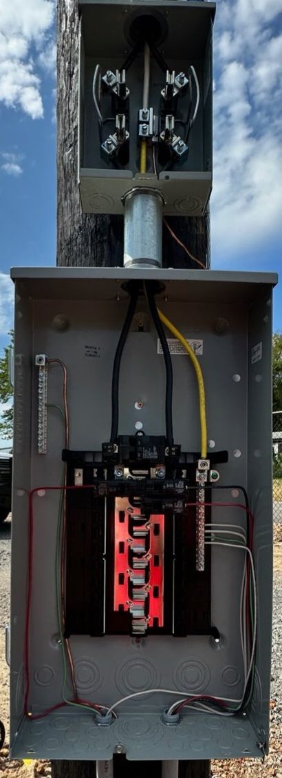 A large electrical box is sitting on top of a pole.