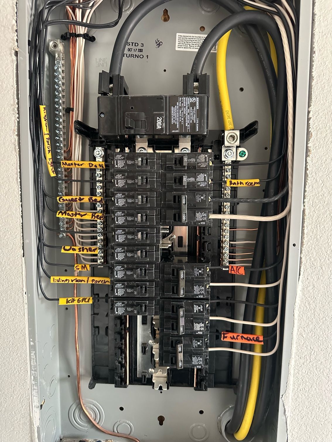 A close up of a electrical panel with a bunch of wires coming out of it