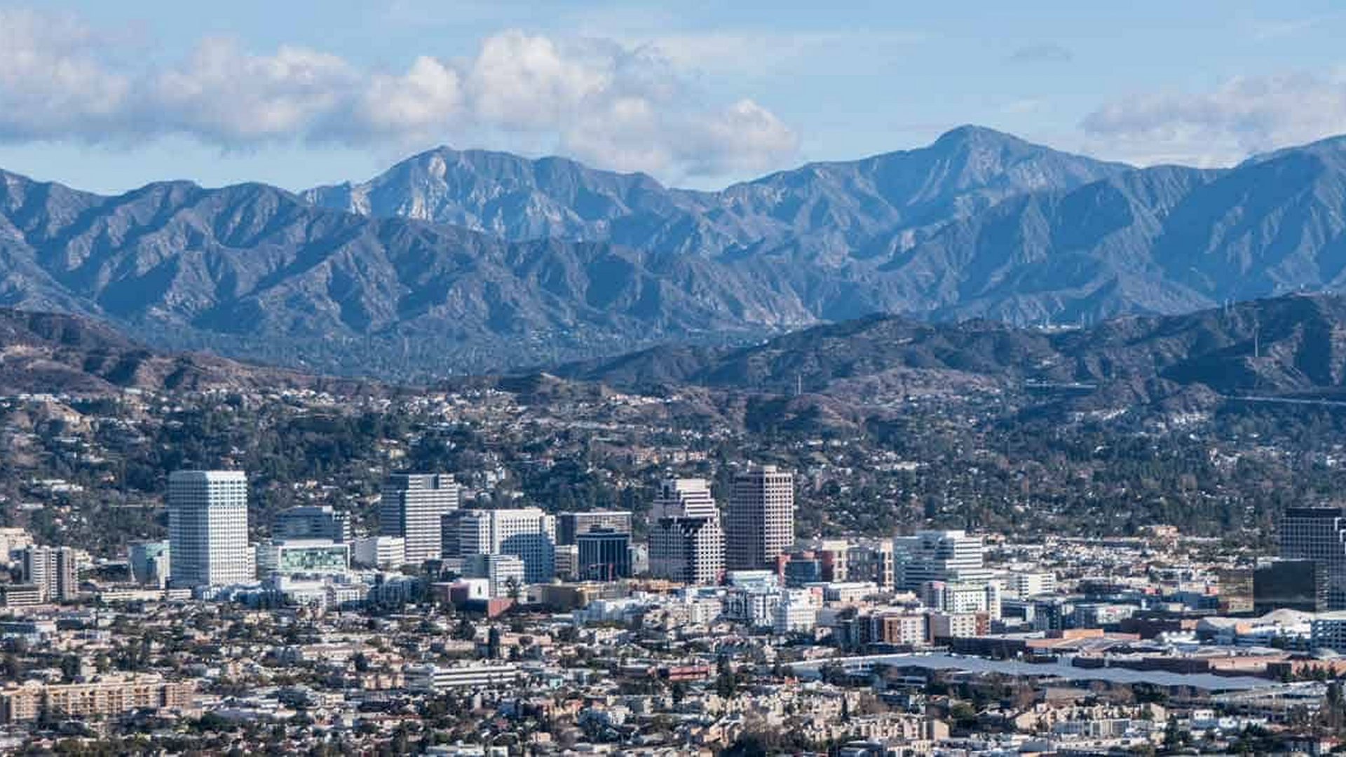 An aerial view of a city with mountains in the background.