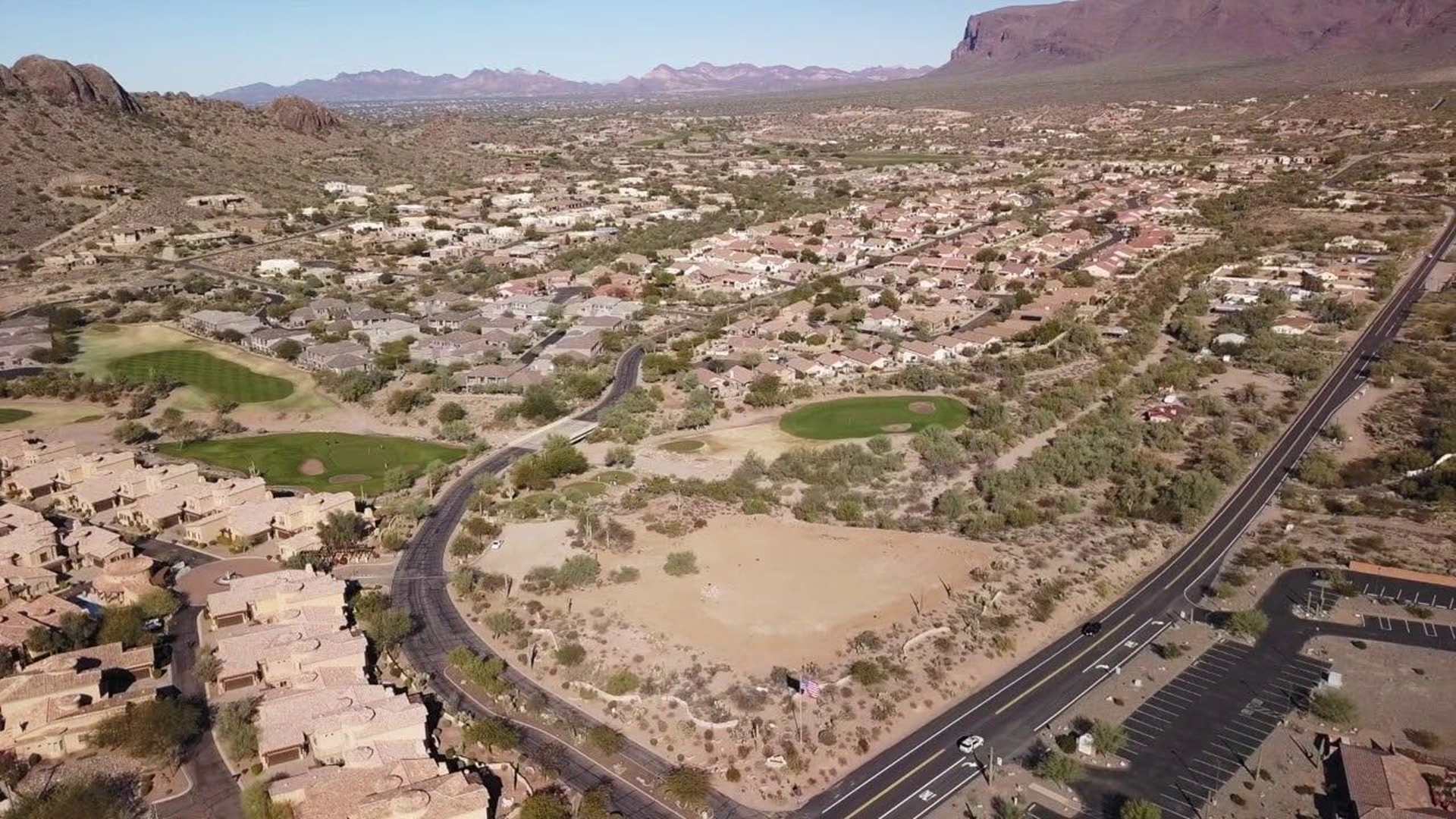 An aerial view of a city in the desert with mountains in the background