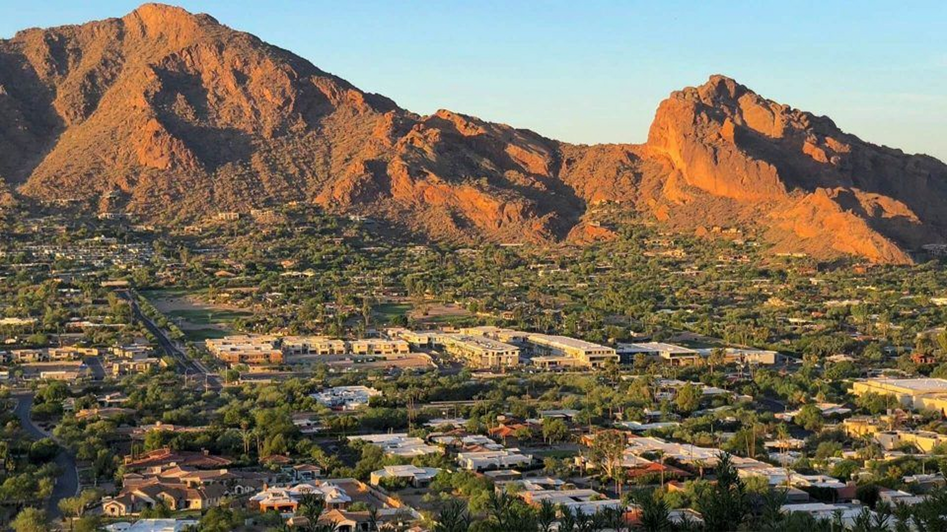 An aerial view of a city with mountains in the background.