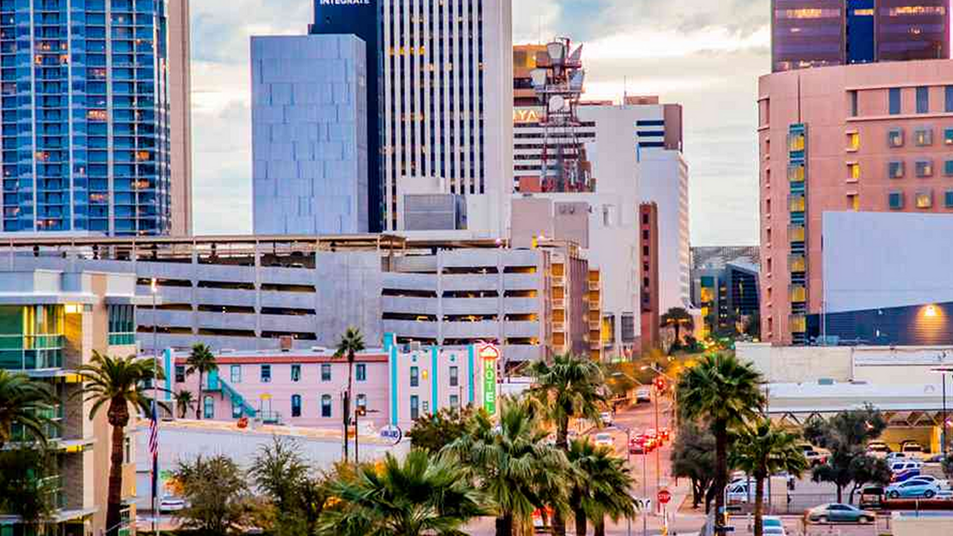 An aerial view of a city skyline with palm trees in the foreground.