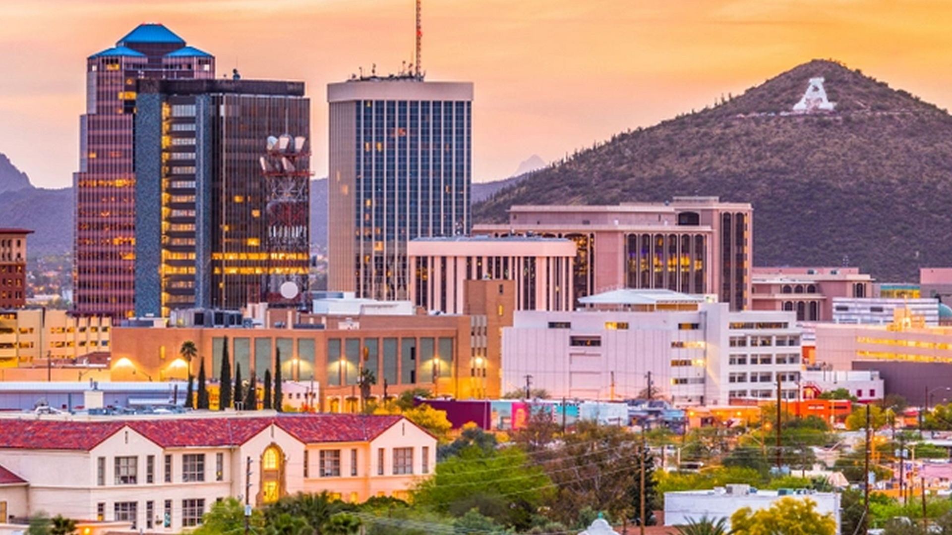 An aerial view of a city skyline with a mountain in the background.