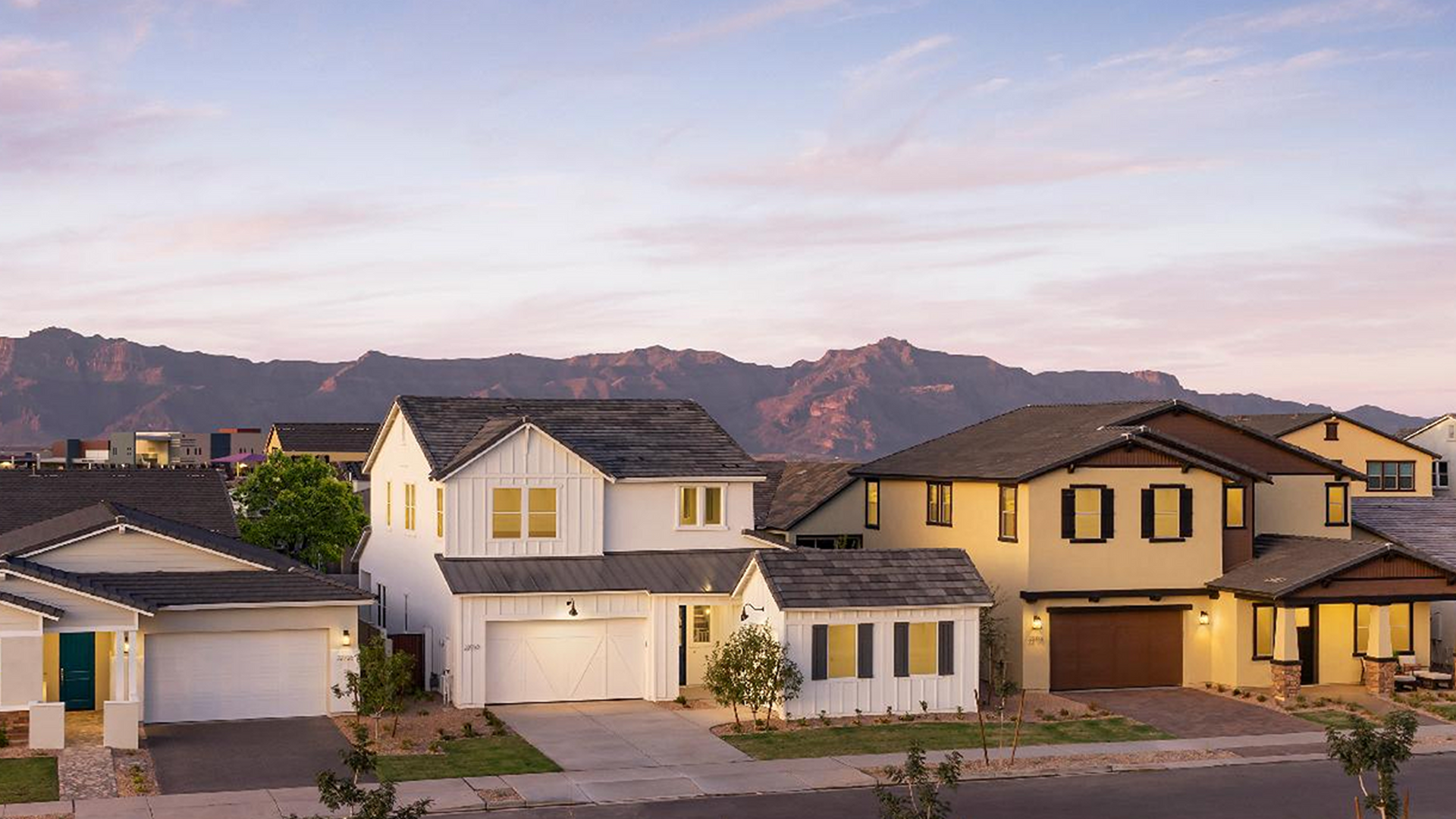 A row of houses in a residential area with mountains in the background.