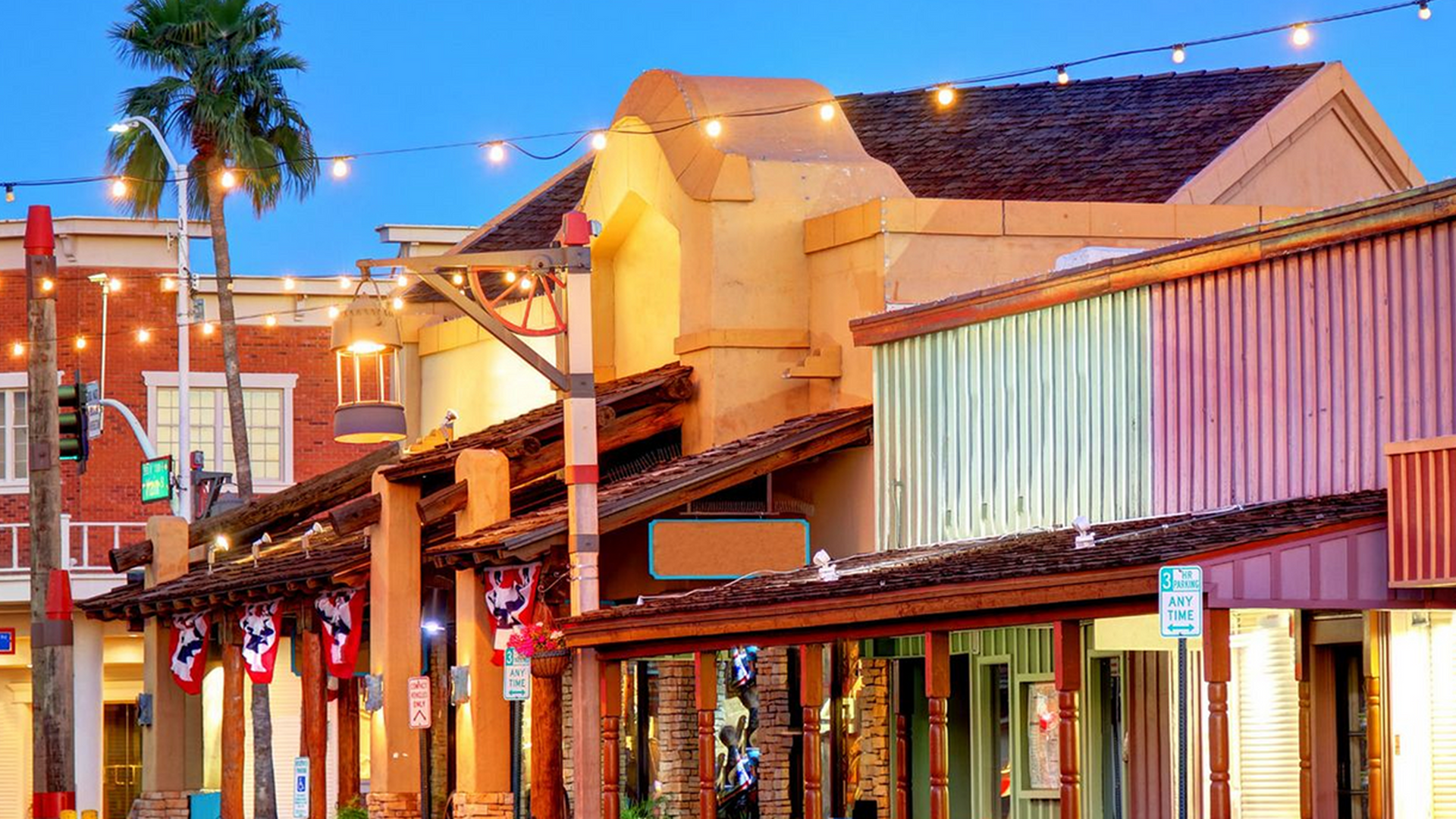 A row of colorful buildings with a palm tree in the background.
