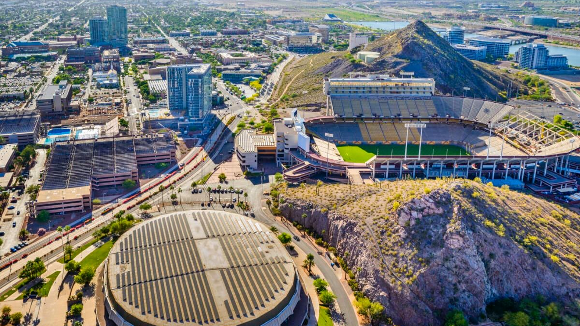 An aerial view of a city with a stadium in the middle of it.
