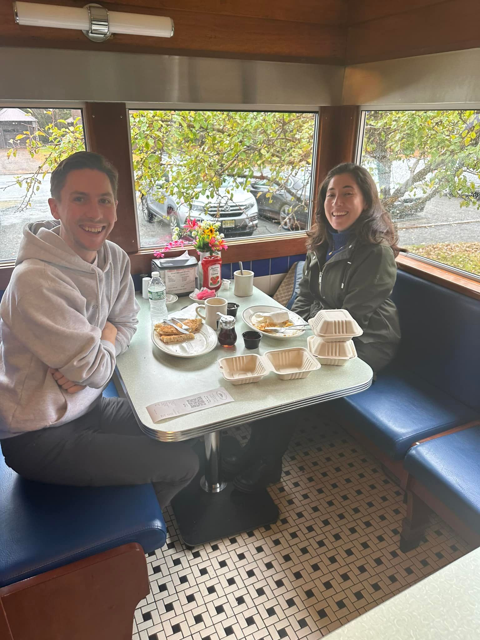 A man and a woman are sitting at a table in a diner.
