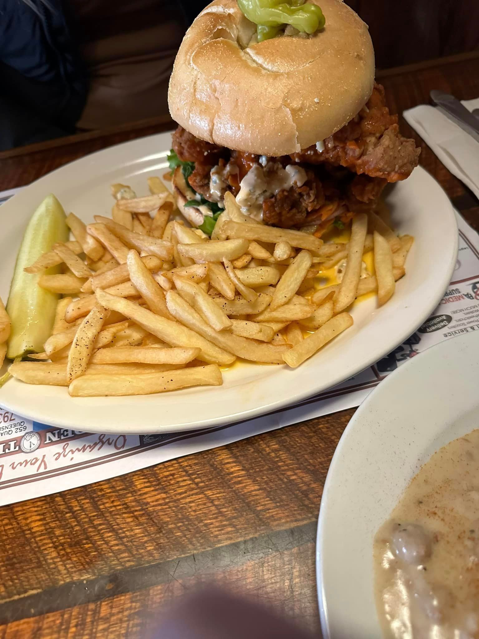 A plate of food with a hamburger and french fries on a table.