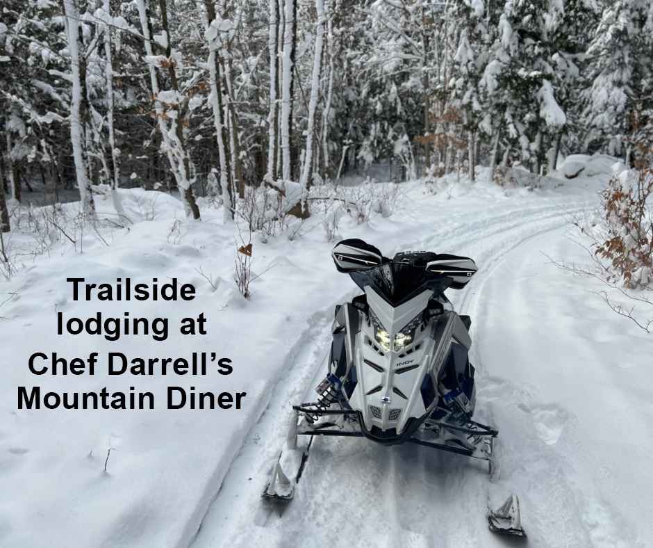 A snowmobile is driving down a snow covered road